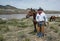 Cowboy wrangler, Johnny Garcia, standing with his bay horse at the Yampa river on annual Great American Horse Drive