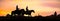 Cowboys couple on horseback at sunset