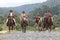 Cowboys in traditional wear riding on a country road