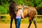 Cowgirl getting horse ready for ride on countryside