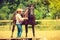 Cowgirl getting horse ready for ride on countryside