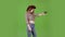 Cowgirl in a hat, cowboy boots and a vest shoots a revolver. Green screen