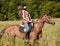 Cowgirl riding a bay horse