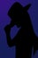 Cowgirl silhouette portrait tipping her hat with a