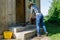 Cowgirl sweep stairs with wooden broom in rural