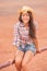 Cowgirl Texas woman smiling happy on country farm ranch wearing cowboy hat , western shirt and jeans shorts. Young