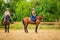 Cowgirl and woman jockey riding on horses