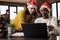 Coworkers in santa hats checking report
