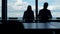 Coworkers silhouettes working office at panorama window. Business team checking