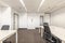 Coworking office, with several work tables and swivel chairs, gray walls, a technical ceiling and gray carpeted floors