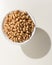 Cowpea legume. Grains in a bowl. Shadow over white table.