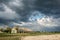 A cowshed in the background of a thunderous landscape