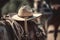 cowwboy hat and rope hanging from saddle of galloping cowboy