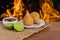 Coxinha. Traditional fried brazilian food with chicken. Background with defocused fire