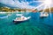 Cozy Assos village in Kefalonia. Colorful boats in azure bay under morning sunlight. Sommer vacation in Greece