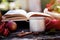 Cozy autumn concept with mug of tea, vintage book, viburnum, apples in rustic style. Autumn aesthetic still life with