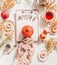 Cozy autumn day flat lay. Lazy kitten in woman hands  on white desk with clipboard and word autumn, pumpkin, apples, mini donuts,