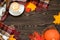 Cozy autumn flat lay with a cup of coffee, warm scarf, pumpkin and colourful leaves on the wooden table. Sale concept.