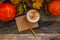 Cozy autumn still life background. Craft envelope, mug of latter coffee ,leaves, pumpkins on vintage wooden background