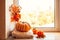 Cozy autumn still life on the windowsill with copy space: pumpkin, warm wool sweaters, maple leaves and persimmon