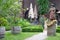 Cozy backyard in old european house. Calm empty yard with sculpture of Saint Jacob and trees in baskets and closed umbrellas.