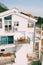 Cozy balconies with wooden garden furniture on the facade of the white building.