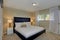 Cozy bedroom features a black bed and beige walls.