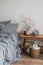 Cozy bedroom in Scandinavian style - linen bed, wooden bench with autumn decor, a basket with a blanket. Home concept