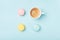 Cozy breakfast. Coffee cup and colorful macaron on pastel blue background top view. Fashion flat lay. Sweet macaroons.