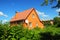 Cozy Brick House with Old faded red metal roof tile and chimney outdoor. Bad Roofing Exterior.