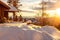 Cozy cabin house in the snowy mountains in the sunset.