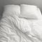 Cozy chaos Messy white bedding sheets and pillows, black and white
