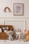 Cozy composition of kids room interior with mock up poster frame, wicker basket, plush animal toys, braided plaid, white stool,
