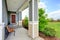 Cozy covered porch with concrete floor, columns and comfortable bench