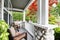 Cozy entrance porch with white columns and wicker chairs.