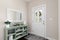 A cozy entryway with decorations on a green console table.