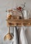 Cozy evening kitchen interior - wooden shelf with lighted candles, a jar of cookies, a jug and linen towels on a hanger in