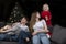 Cozy family evening - mom and three happy smiling children against the background of the Christmas tree