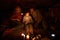 Cozy family evening. Mothr, faher and little girl sitting on sofa without electricity and reading book with candle light