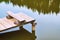 Cozy fishing bench on a wooden pier at the shore of a calm pond or lake in summer nountains