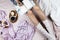 Cozy flatlay with white tanned woman in white socks sitting in her bed with cup of black coffee