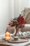 Cozy home composition with candles and protea bouquet.