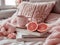 Cozy Home Interior with Warm Knitted Blanket, Book Pile, Fresh Grapefruit Slices, and Comforting Hot Beverage on Bed