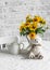 Cozy home still life-a bouquet of yellow flowers, teapot, soft toy bear on the bright kitchen table