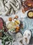 Cozy home still life - soft slippers, knitted sweater, plaid, green tea with honey, tangerines, dry leaves, books on a light