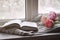 Cozy home still life: spring flowers and opened book with warm plaid on windowsill. Springtime concept, free copy space