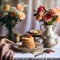 Cozy Homemade Breakfast Pancakes with Apple Sauce, Vintage Dishes, and Dahlias Bouquet on a Retro Tablecloth