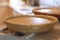 Cozy, homey image of two pumpkin pies cooling in a kitchen. Backlighting and shallow depth of field used. Image is in warm tones t