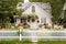 cozy house with warm and welcoming exterior, including a white picket fence and blooming flowers