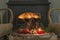 Cozy interior with burning stove, two glass of wine and fruits of tree stump